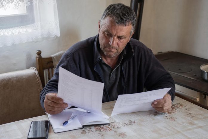 Земјоделец проверува банкарски извод и решение за исплата
